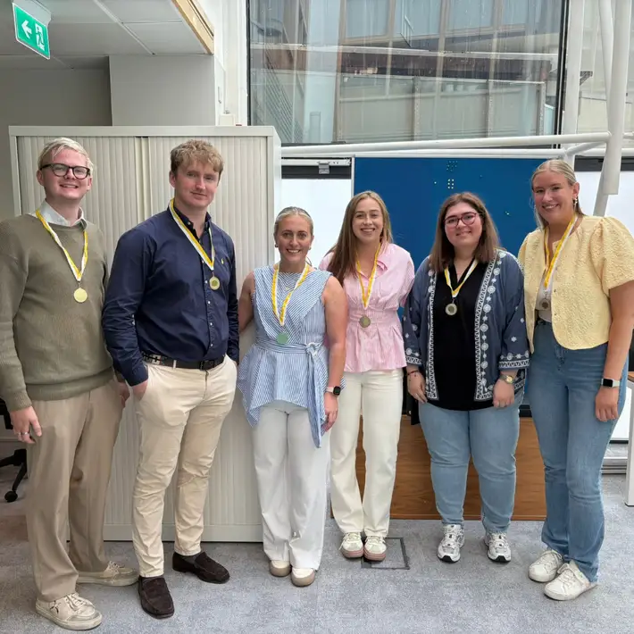 winning team of graduates after winning code breaker with medals around the necks