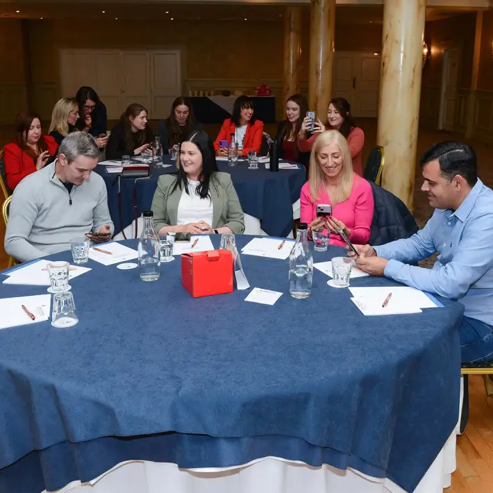 Large group seated at round tables during the Remote Host Digital Treasure Hunt briefing session at the Galway Bay Hotel