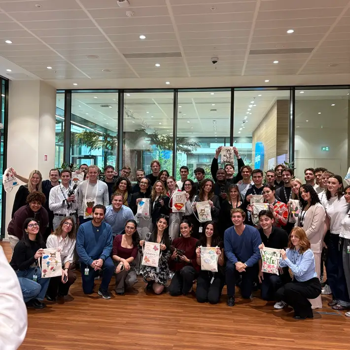 Corporate team in Ireland after completing The Hand Project CSR workshop, holding decorated donation bags with prosthetic hands for charity.