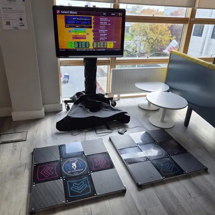 Two-player dance mat game set up in an office canteen for a company milestone celebration