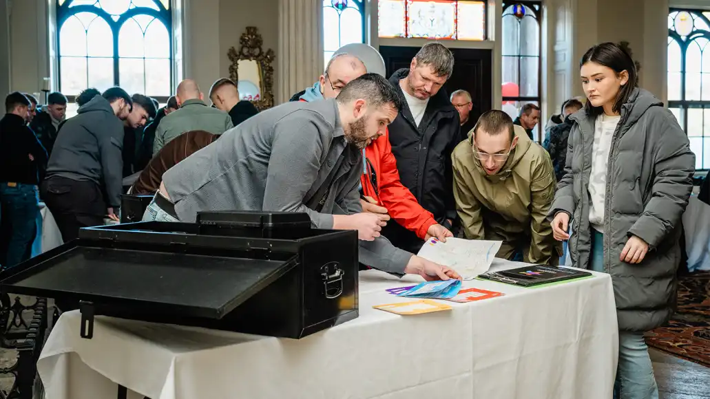 Large corporate group working together on a team building challenge at an indoor event