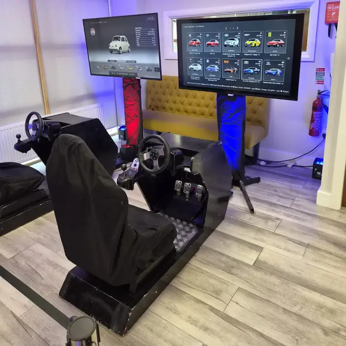 Racing simulator pods with steering wheels and pedals at PrepayPower’s onsite staff celebration
