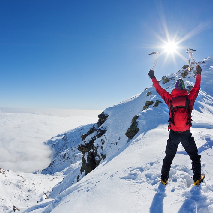 Mountaineer walking uphill along a snowy slope