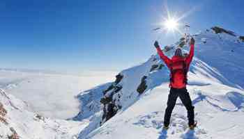 Mountaineer walking uphill along a snowy slope