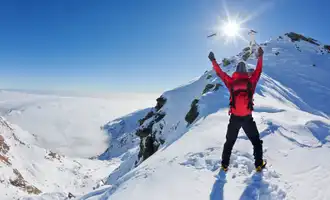 Mountaineer walking uphill along a snowy slope