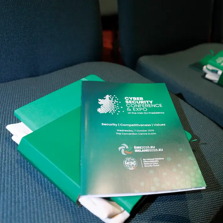 Branded NCSC Cyber Security Conference & Expo programme and green delegate materials arranged on a conference chair.