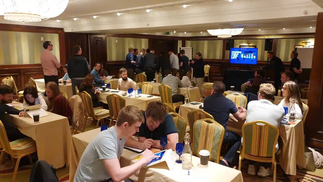 Team members deep in discussion and negotiation during the Trading Table collaboration activity.