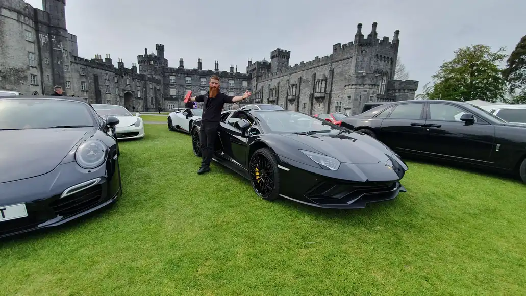 Corporate team building event at Kilkenny Castle with luxury supercars on display during a Dynamic Events treasure hunt activity.