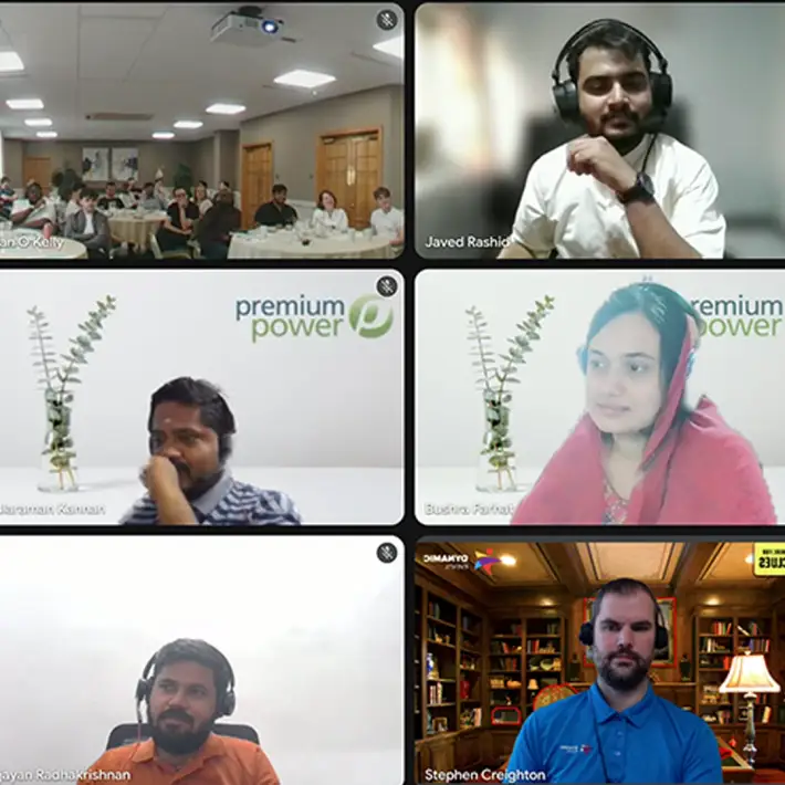 Hybrid team building event with Premium Power staff, showing in person participants at the Grand Hotel Malahide and remote colleagues joining online from around the world during a Dynamic Events escape game.