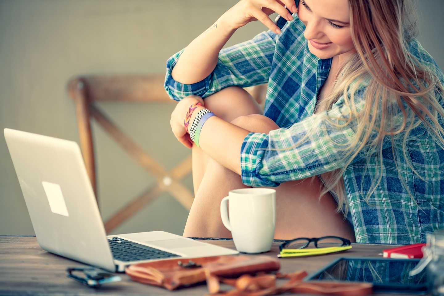 young business woman working online, sitting in cafe with her laptop and speaking on the phone, modern life of young people