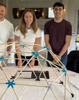 MBA students during a Team Development Day in Ireland, working together on the Domeworks activity to build a geodesic dome and strengthen collaboration skills.
