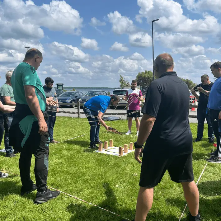 Participants constructing a tall structure using lightweight materials during a collaborative tower challenge.