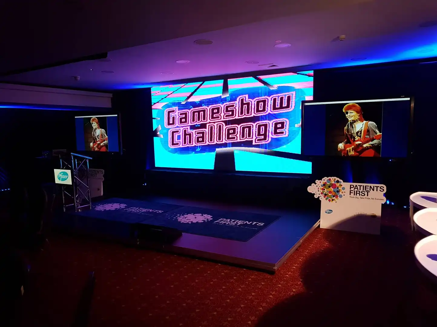 Gameshow Challenge set with podiums, lighting, and large screen