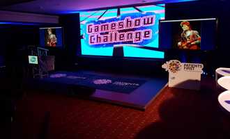 Gameshow Challenge set with podiums, lighting, and large screen