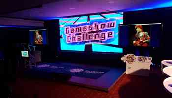 Gameshow Challenge set with podiums, lighting, and large screen
