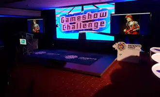 Gameshow Challenge set with podiums, lighting, and large screen