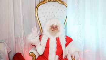 Santa Claus greeting attendees from his throne during a Christmas team building event designed for corporate teams and employee engagement.