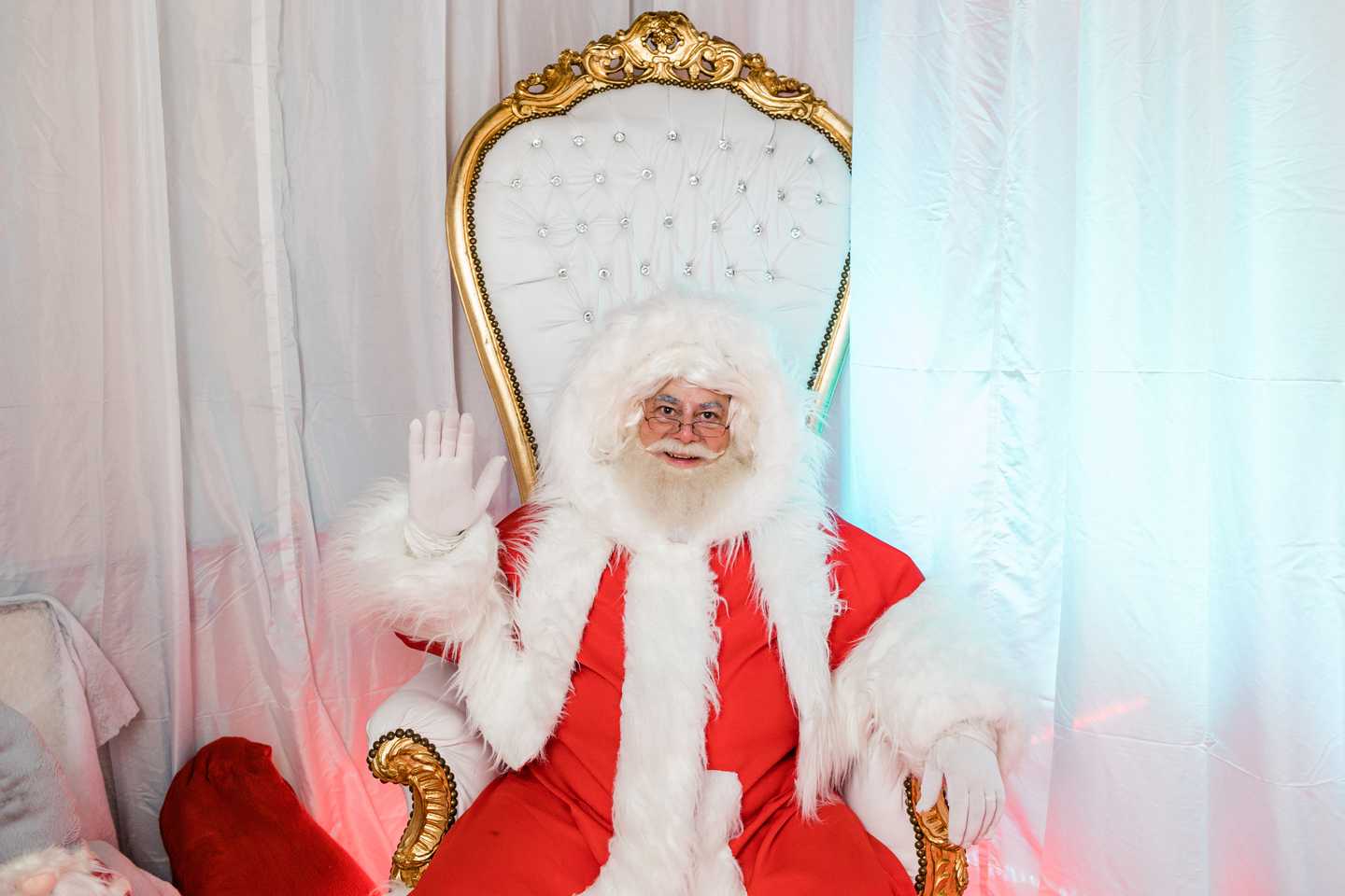 Santa Claus greeting attendees from his throne during a Christmas team building event designed for corporate teams and employee engagement.