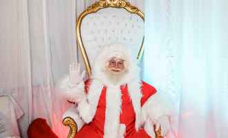 Santa Claus greeting attendees from his throne during a christmas team building activity designed for corporate teams and employee engagement.