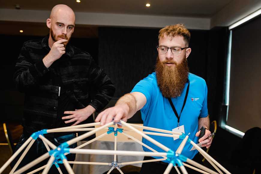Corporate team training workshop in Dublin with facilitator guiding group in Dome Works experiential learning activity.