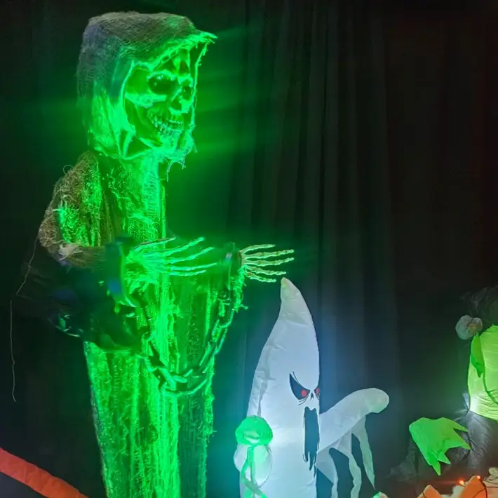 skull decoration with green uplights and a blow up ghost underneath