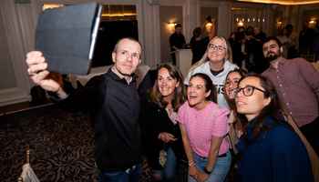 Team participating in a remote-hosted digital treasure hunt in Ireland, using a tablet to complete challenges during a corporate team building event.