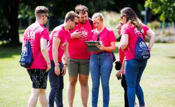 Corporate team using an app during a digital treasure hunt in Dublin smiling and celebrating together outdoors