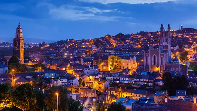 Overview photo of cork at night time with lights and building