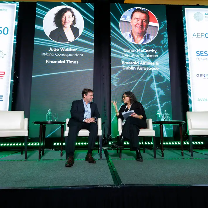 Jude Webber and Conor McCarthy talking together as a panel up on stage sitting on couch chairs 