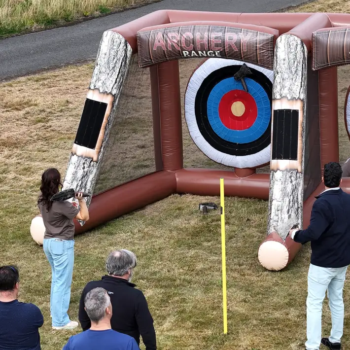 Moore Ireland staff trying inflatable archery activity during outdoor team building event at Heritage Hotel Killenard by Dynamic Events Ireland