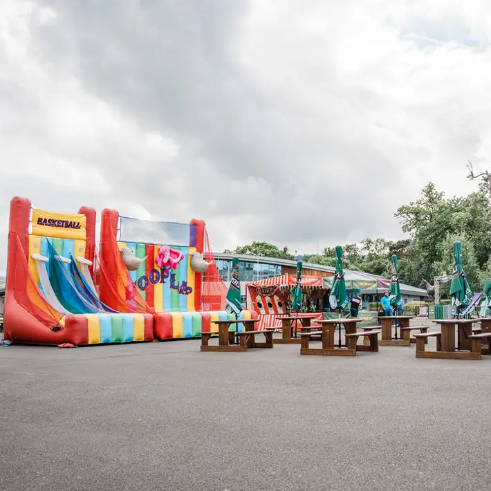 Outdoor corporate event space with food trucks, bar, and marquee tents and carnival games