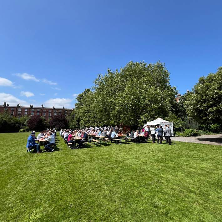 SMBC team members seated on picnic benches enjoying an outdoor corporate lunch in Fitzwilliam Square, Dublin.