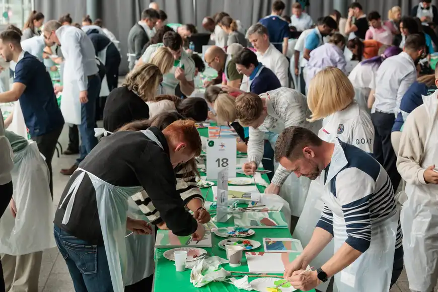 Corporate teams painting canvases together during a collaborative Big Picture team building activity in Ireland