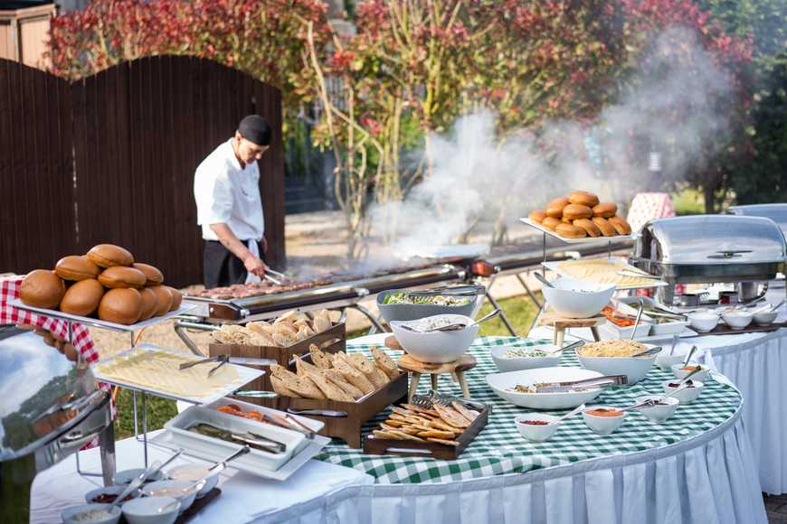 Chef grilling burgers and bread displayed on buffet table at summer BBQ corporate team building event at Killashee