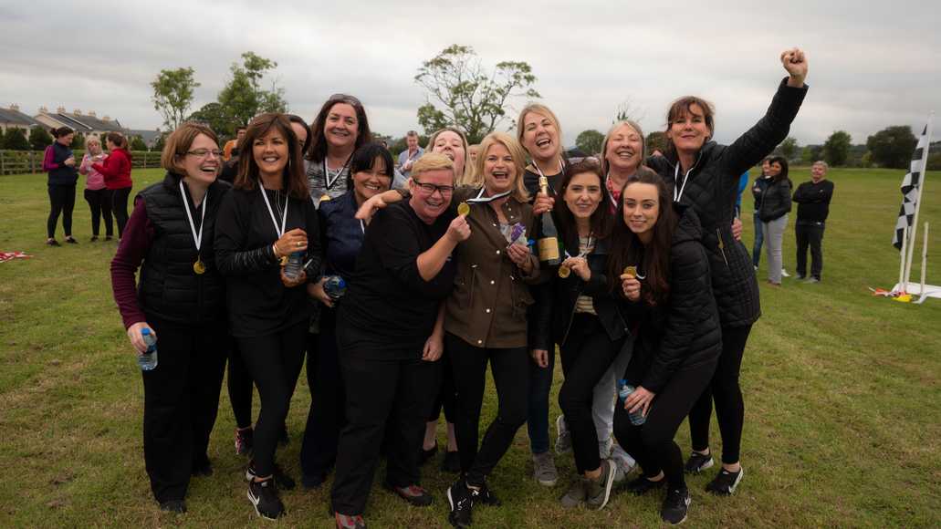 Corporate team celebrating together after completing outdoor team building challenge in Shannon