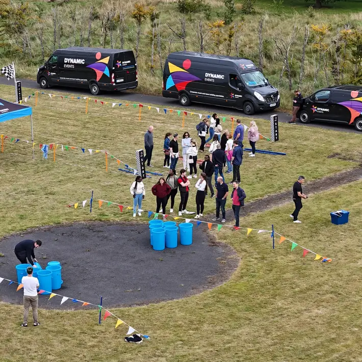 Moore Ireland employees taking part in outdoor team building challenges at the Heritage Hotel Killenard with Dynamic Events Ireland vans on site
