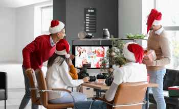 Corporate team enjoying a hybrid virtual Christmas party with festive decorations