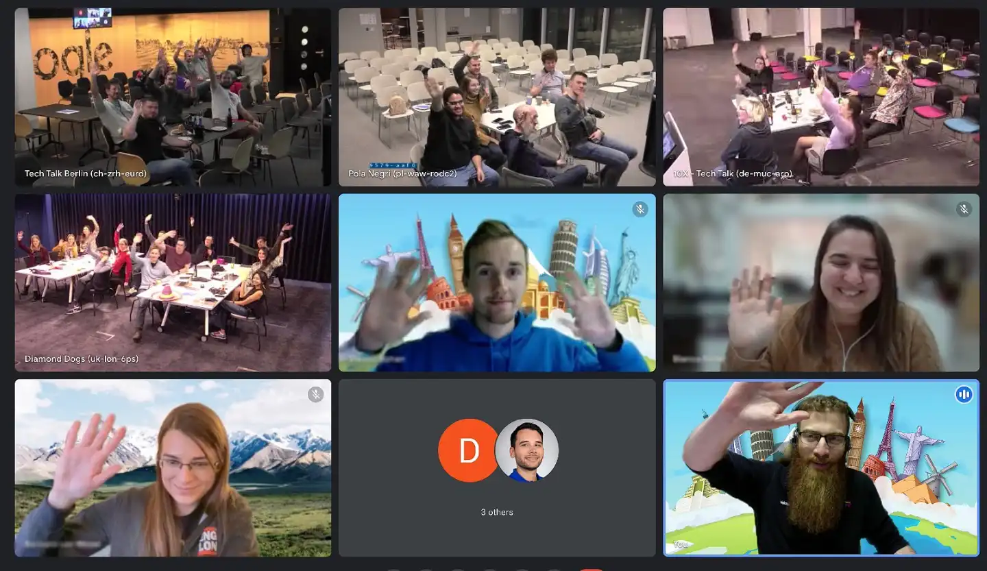 Multiple hybrid team locations on screen, with both remote participants and in-office groups waving and smiling.