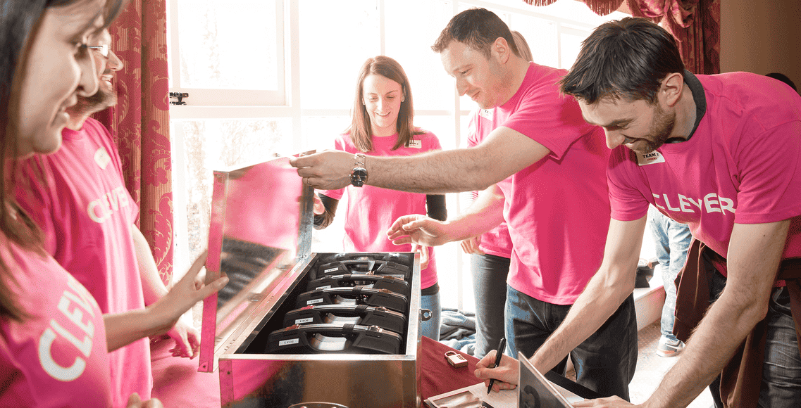 Corporate team in Dublin working on Code Breaker escape game, opening puzzle box during team building activity.