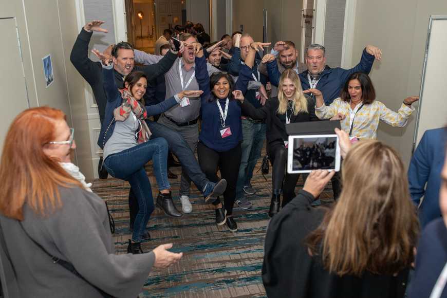 Team posing enthusiastically for a creative photo challenge during interactive quiz activity