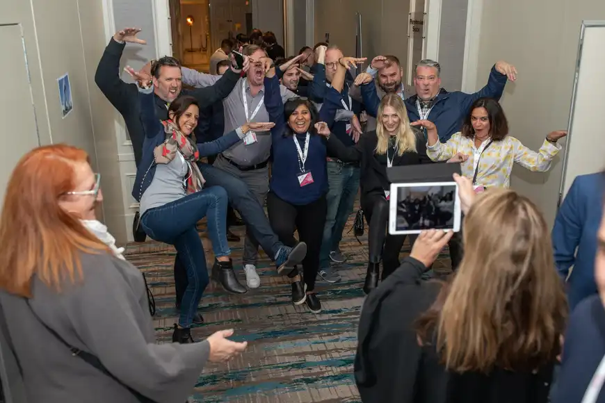 Team posing enthusiastically for a creative photo challenge during interactive quiz activity