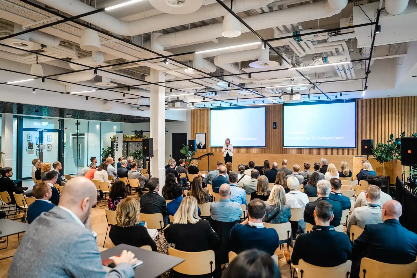 Corporate presentation event at Qualtrics Dublin office, with a speaker addressing employees in a professionally equipped event space.