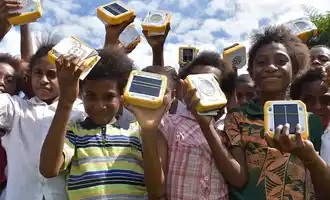 Children holding SolarBuddy lights distributed through corporate sustainable team building initiative