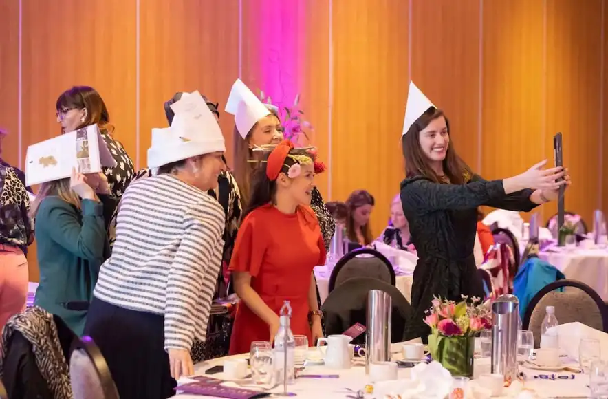 Corporate group celebrating International Women’s Day while engaging in a Level Up creative problem solving activity.