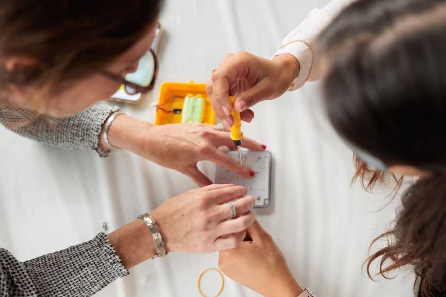 Close-up of hands assembling solar lights at SolarBuddy CSR team building workshop