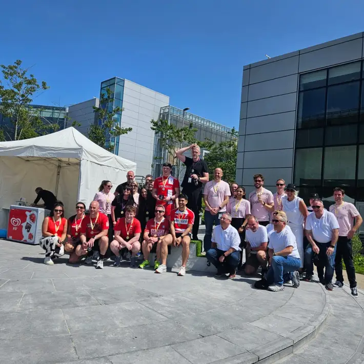 Winners on podium holding medals and sweets at Apple’s summer sports day