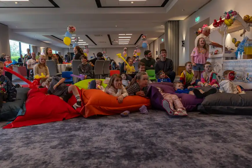 Kids laughing at a puppet show sitting on colourful beanbags | Galway event Management