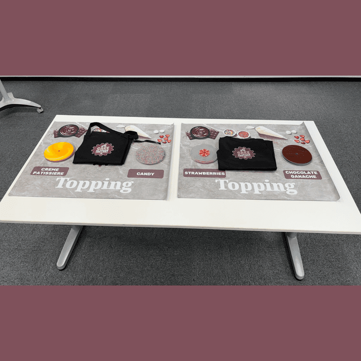Topping station with aprons on the table and ingredients