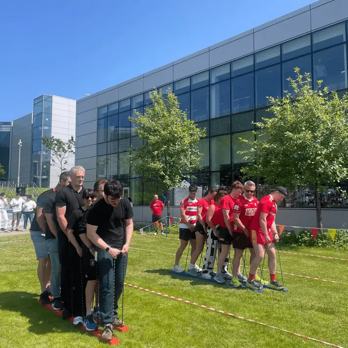 Group of colleagues in team t-shirts taking part in Skis during team building event