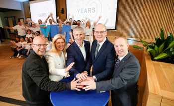 Corporate offsite event with Irish business leaders celebrating 10 year anniversary surrounded by team members at a modern venue in Ireland